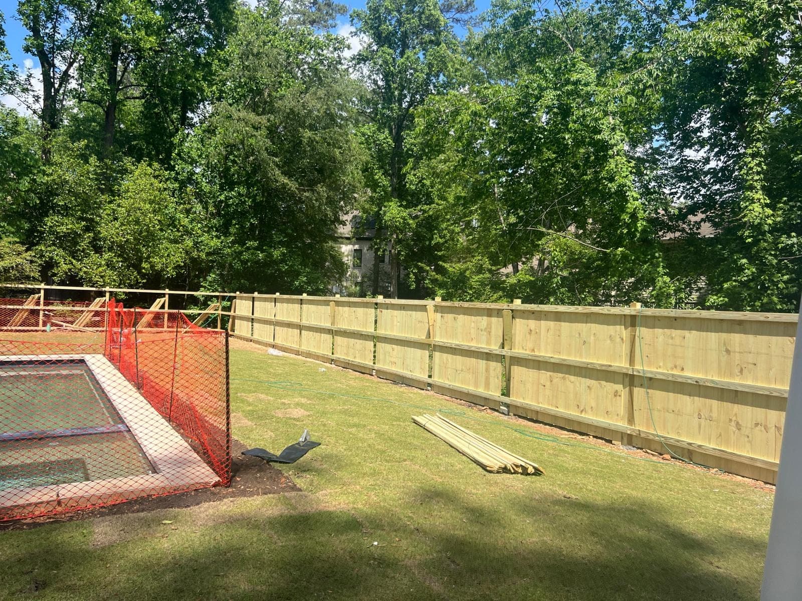 Alpha crew mid-build: pressure-treated privacy fence going up around a pool in Metro Atlanta